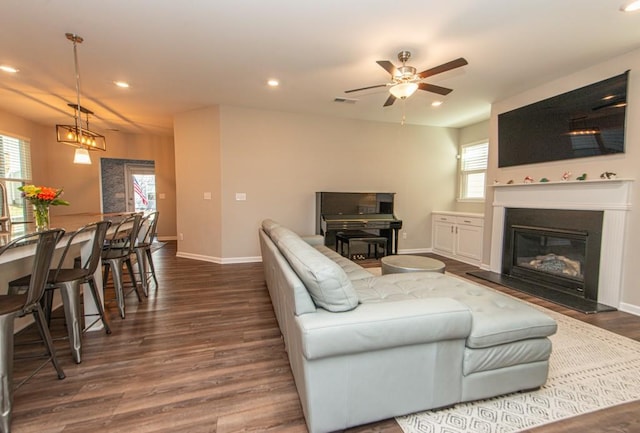 living area featuring recessed lighting, baseboards, dark wood-style flooring, and plenty of natural light