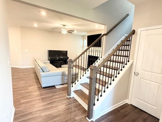 stairs featuring ceiling fan, baseboards, wood finished floors, and recessed lighting