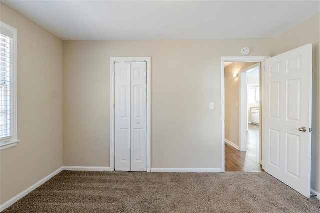 unfurnished bedroom with a closet, baseboards, and carpet