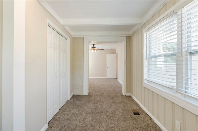 corridor with visible vents, crown molding, baseboards, carpet floors, and beam ceiling