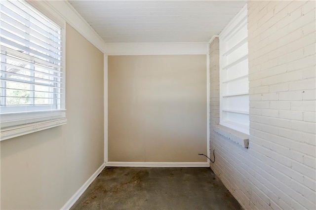 empty room with baseboards, built in shelves, and unfinished concrete floors