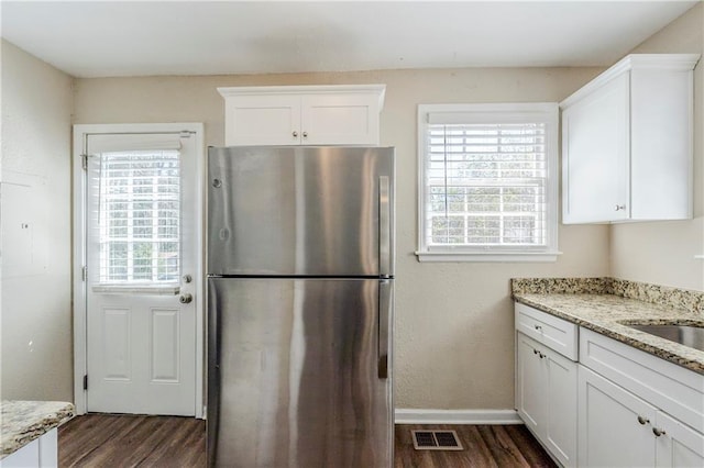 kitchen featuring dark wood finished floors, visible vents, white cabinetry, and freestanding refrigerator