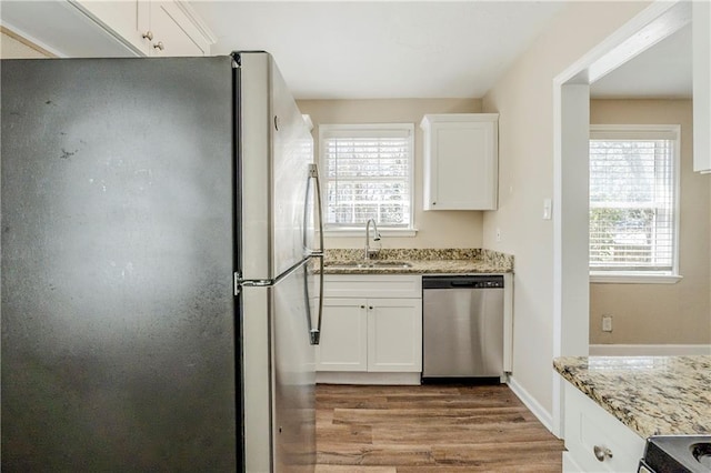 kitchen featuring a sink, plenty of natural light, white cabinetry, and stainless steel appliances