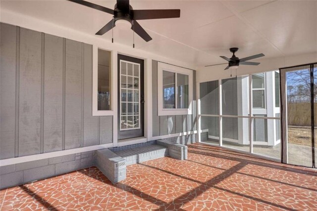 unfurnished sunroom with a water view and ceiling fan