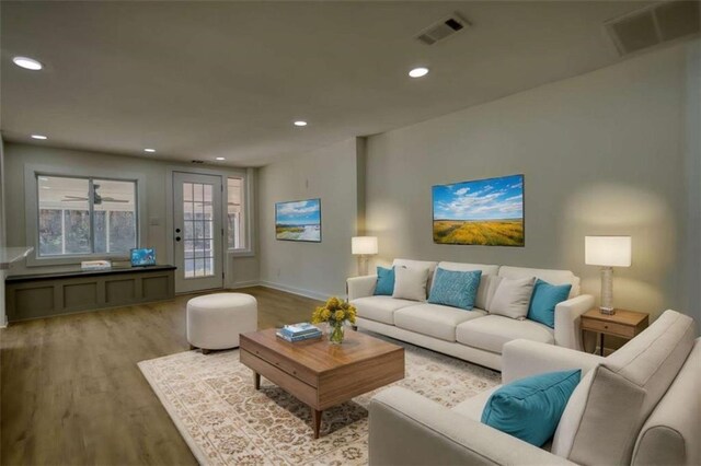 kitchen with appliances with stainless steel finishes, sink, gray cabinetry, a kitchen island with sink, and light hardwood / wood-style floors