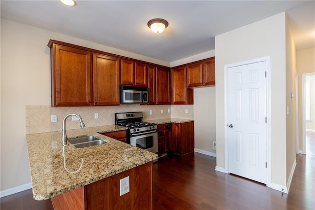 4400 Village Field Pl, Suwanee, GA 30024 - kitchen featuring appliances with stainless steel finishes, a sink, a peninsula, light stone counters, and tasteful backsplash