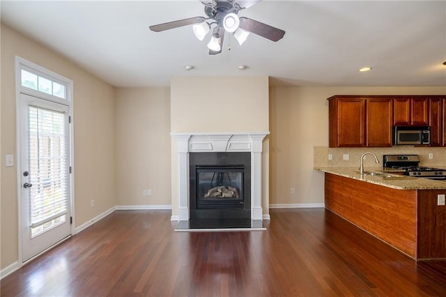 4400 Village Field Pl, Suwanee, GA 30024 - kitchen featuring stainless steel appliances, brown cabinets, light stone counters, dark wood-style floors, and recessed lighting