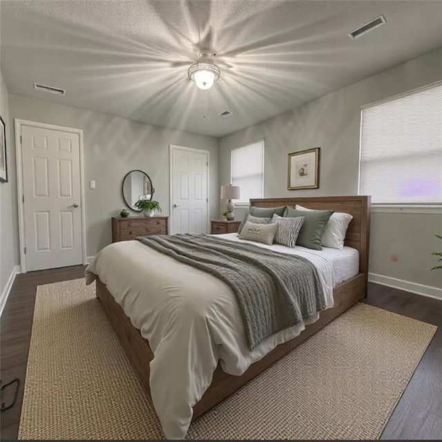 bedroom featuring multiple windows, dark hardwood / wood-style flooring, and ceiling fan