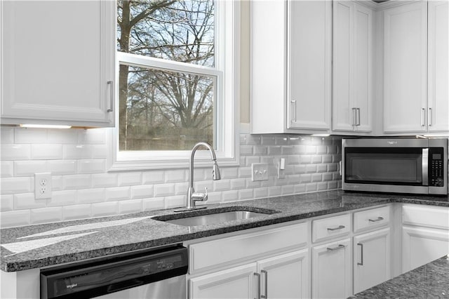 kitchen with appliances with stainless steel finishes, white cabinets, and a sink