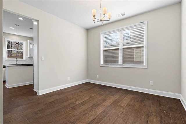 unfurnished room featuring a chandelier, recessed lighting, dark wood-type flooring, visible vents, and baseboards