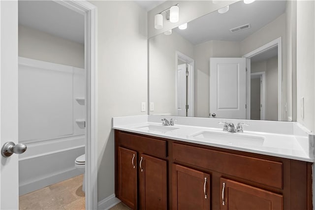 full bathroom with visible vents, a sink, toilet, and double vanity