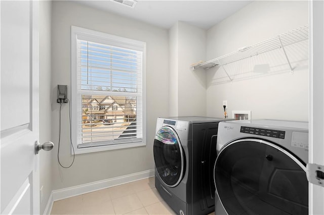 laundry room featuring laundry area, light tile patterned floors, visible vents, baseboards, and washer and clothes dryer