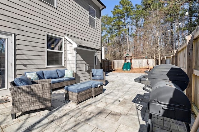 view of patio featuring a fenced backyard, an outdoor hangout area, a playground, and area for grilling