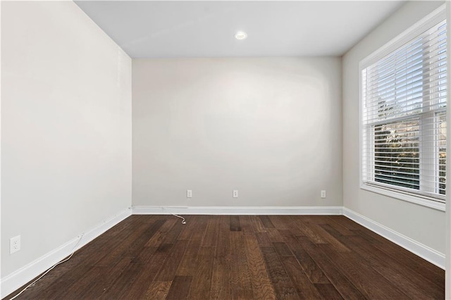 unfurnished room with dark wood-type flooring and baseboards