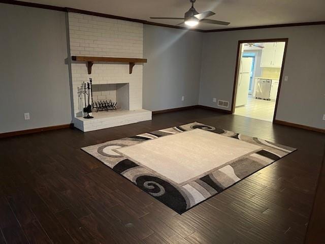 unfurnished living room with ceiling fan, dark hardwood / wood-style flooring, ornamental molding, and a fireplace