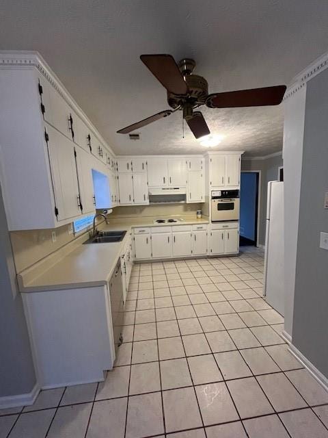 kitchen featuring ornamental molding, white appliances, sink, light tile patterned floors, and white cabinetry