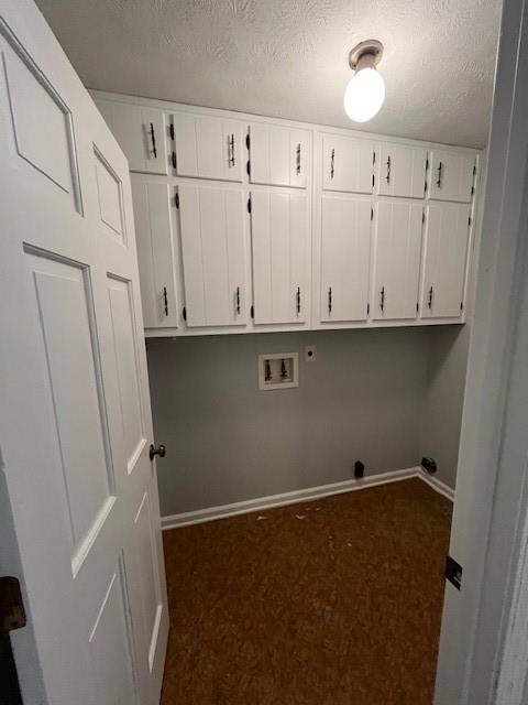 washroom with dark colored carpet, cabinets, a textured ceiling, and hookup for a washing machine