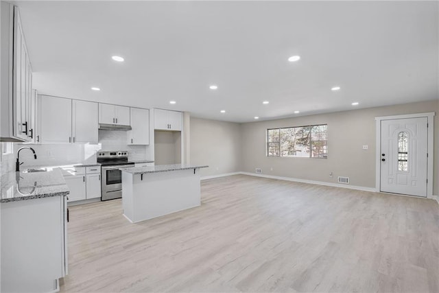 kitchen featuring sink, white cabinets, a center island, electric range, and light hardwood / wood-style flooring