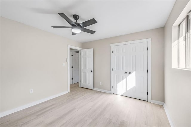 unfurnished bedroom featuring ceiling fan, light wood-type flooring, and a closet