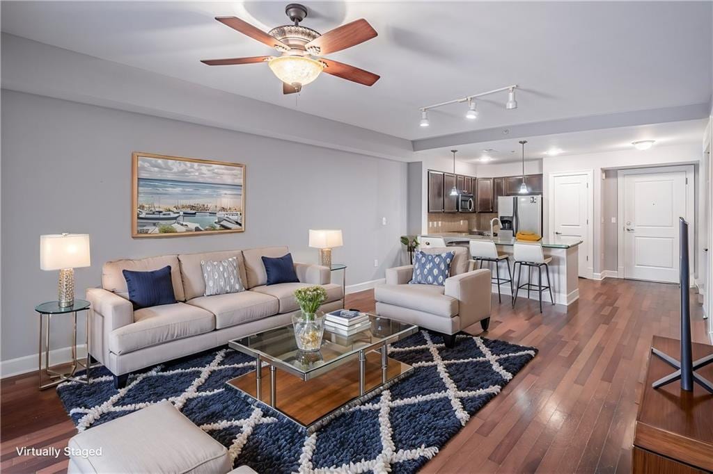 living room featuring dark wood-type flooring, ceiling fan, track lighting, and sink