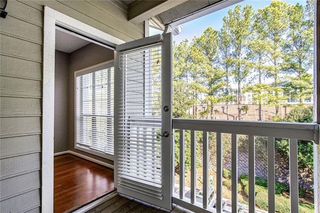 doorway with hardwood / wood-style floors and wooden walls