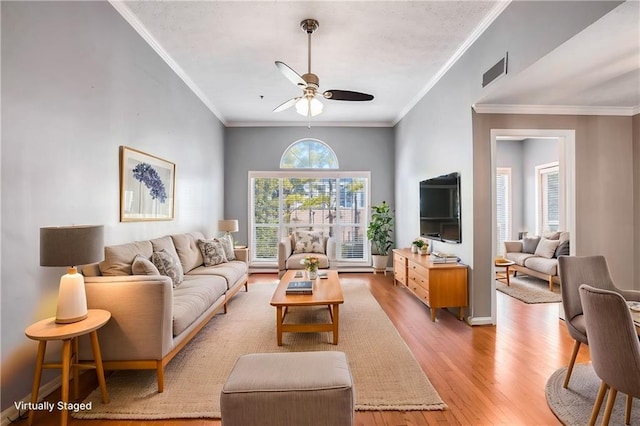 living room with ornamental molding, ceiling fan, and light wood-type flooring