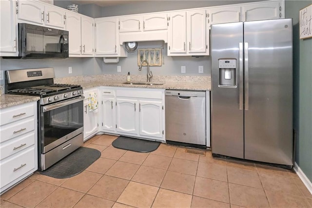 kitchen with a sink, stainless steel appliances, and white cabinetry