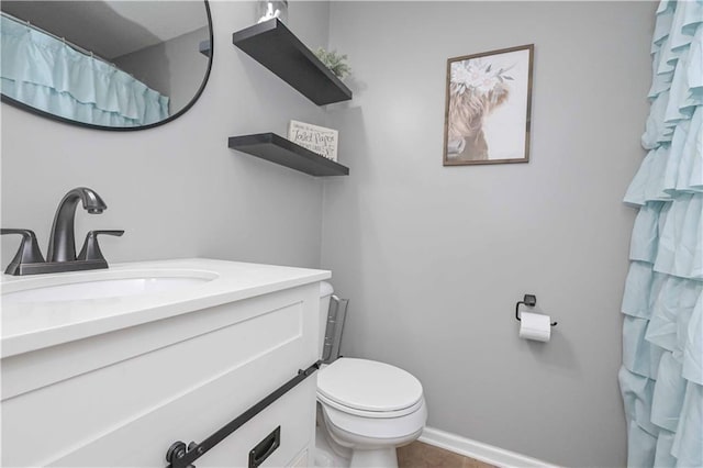 bathroom with vanity, baseboards, and toilet