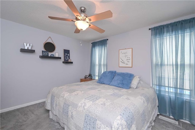 bedroom with carpet floors, a ceiling fan, a textured ceiling, and baseboards