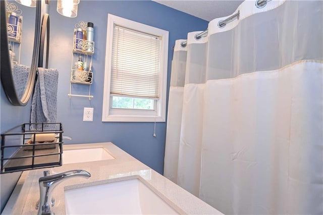 bathroom with double vanity, a shower with curtain, and a sink