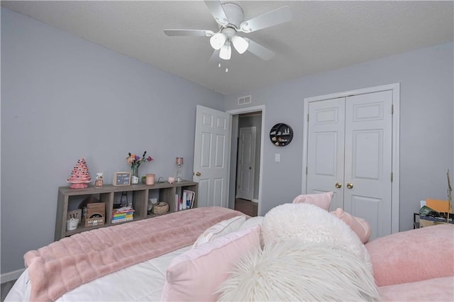 bedroom with visible vents, baseboards, ceiling fan, and a closet