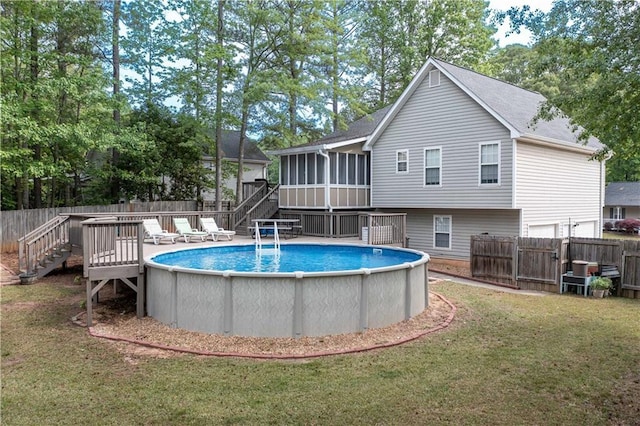 view of pool with a deck, a sunroom, stairway, a fenced in pool, and fence