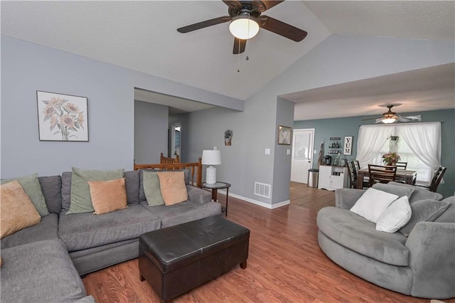 living room featuring high vaulted ceiling, a ceiling fan, wood finished floors, and visible vents
