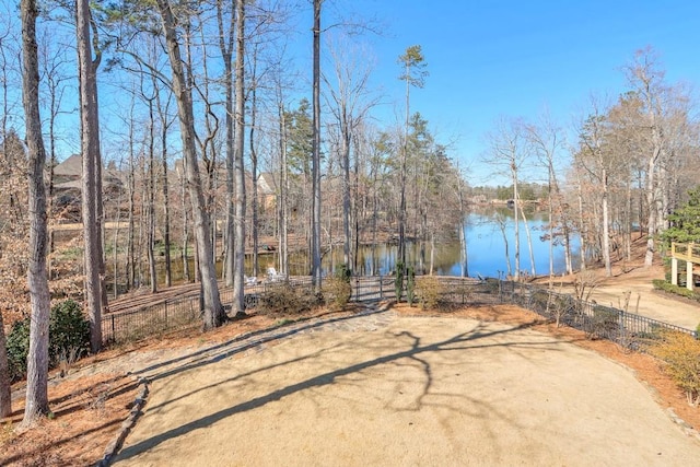 view of yard featuring a water view and fence