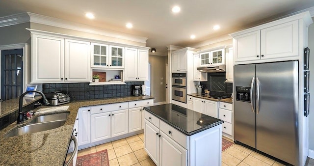kitchen with appliances with stainless steel finishes, a sink, under cabinet range hood, and light tile patterned floors