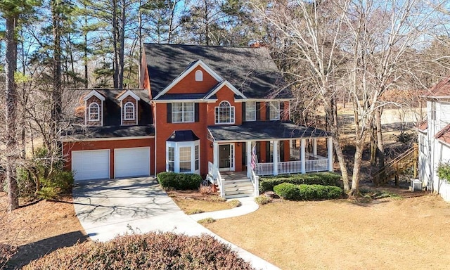 colonial home featuring driveway, a porch, and an attached garage