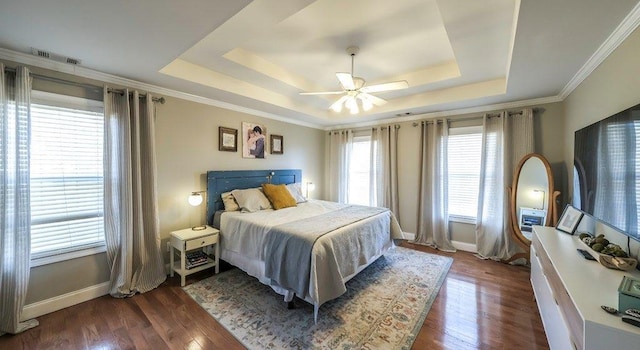 bedroom featuring baseboards, visible vents, a tray ceiling, and dark wood finished floors