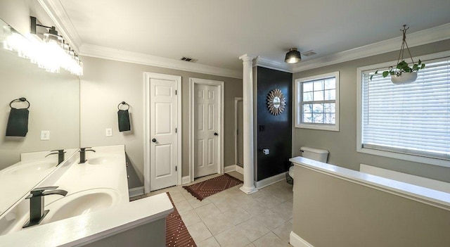 bathroom featuring ornate columns, crown molding, and a sink