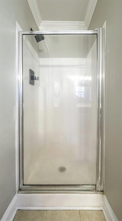 bathroom with a stall shower and crown molding