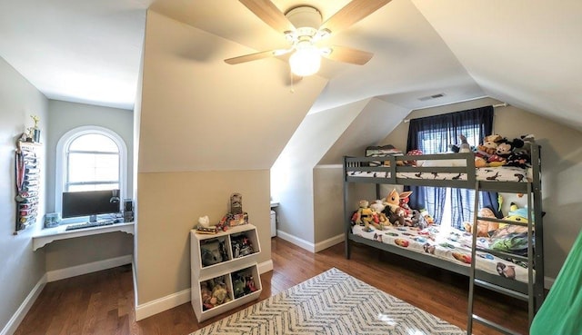 bedroom featuring lofted ceiling, baseboards, and wood finished floors