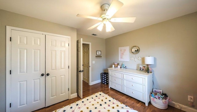 bedroom with a closet, visible vents, dark wood-type flooring, a ceiling fan, and baseboards