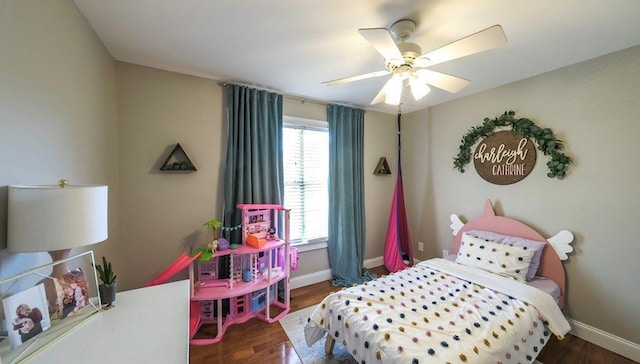 bedroom with a ceiling fan, baseboards, and wood finished floors