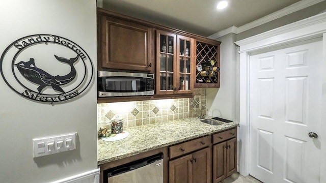 bar with indoor bar, crown molding, backsplash, appliances with stainless steel finishes, and a sink