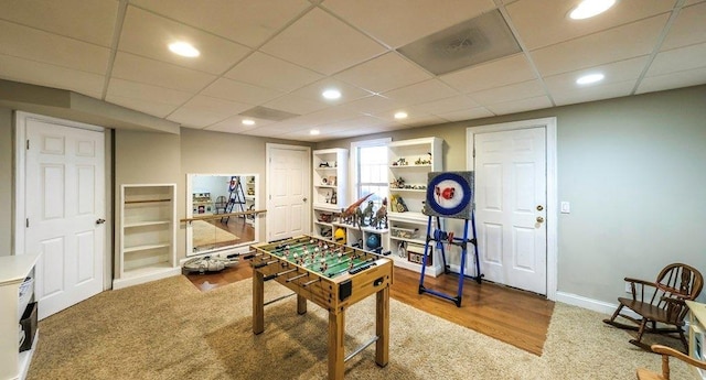 game room with a paneled ceiling, baseboards, wood finished floors, and recessed lighting
