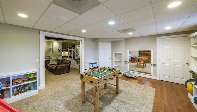 recreation room featuring wood finished floors, a paneled ceiling, and recessed lighting