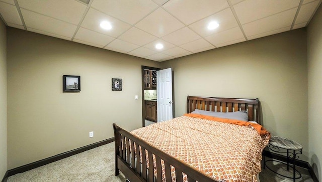 carpeted bedroom with a paneled ceiling, baseboards, and recessed lighting