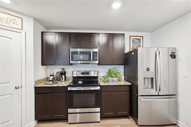 kitchen with light stone countertops, appliances with stainless steel finishes, and dark brown cabinets