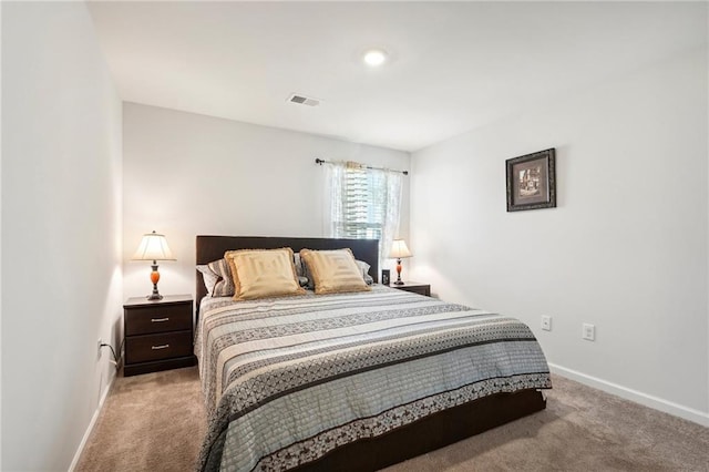 carpeted bedroom with visible vents and baseboards