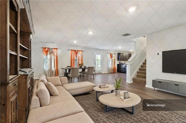 living room with stairs, visible vents, and wood finished floors