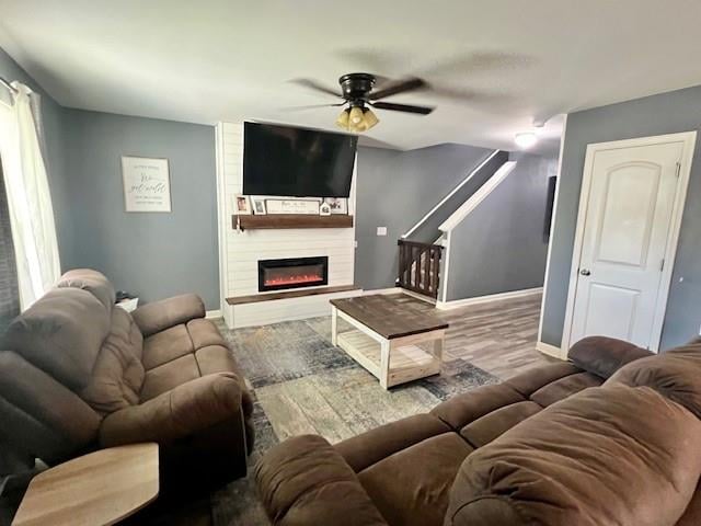 living room featuring a fireplace, hardwood / wood-style flooring, and ceiling fan